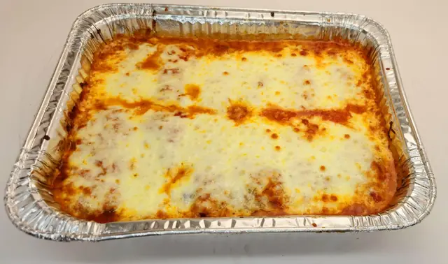 Baked ziti tray under melted mozzarella