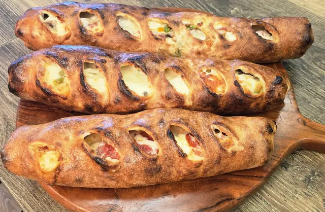 Baked strombolis on a wooden board